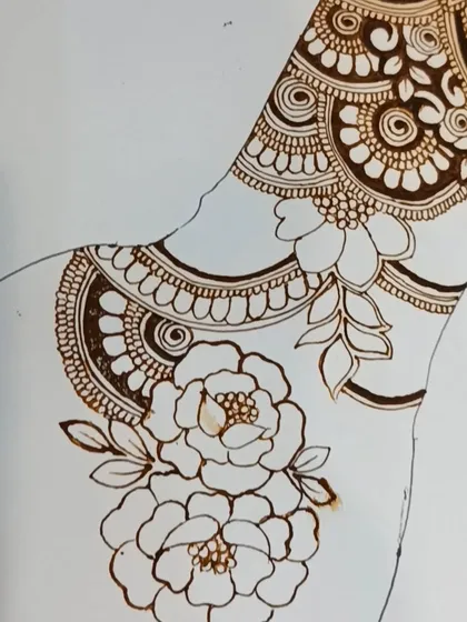 A practice drawing of a jewelry-style design, with hanging elements and floral patterns.