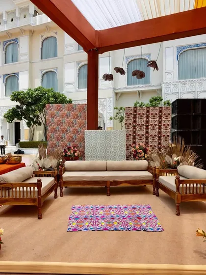 A seating area with a backdrop of traditional printed panels and a vibrant rug, perfectly blending modern comfort with cultural aesthetics.