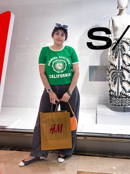 Posing outside the store with my shopping bag. This casual outfit, featuring a graphic tee and jeans, is a go-to for a comfortable and successful day of retail therapy.