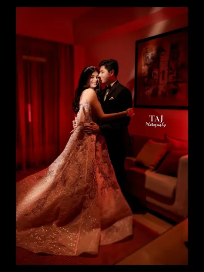 A dramatic and romantic portrait of a couple in a room bathed in red light. The bride's flowing gown adds a touch of fairytale elegance.