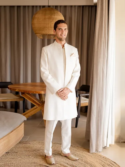 A picture of refined elegance. For this beach wedding, we styled the groom in a custom ivory sherwani by Lalit Laungani, a look that is both sophisticated and perfectly suited to the serene coastal setting.