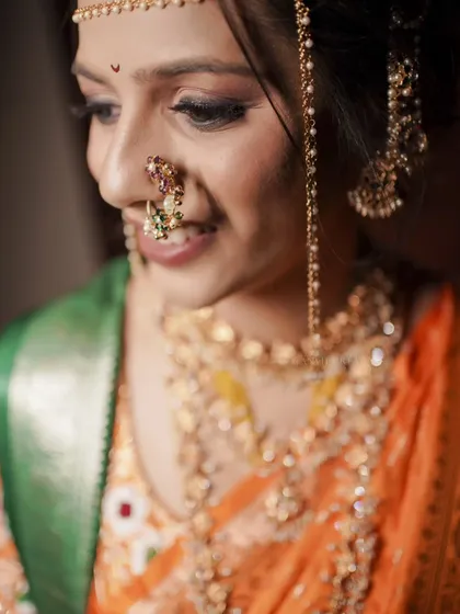 A close-up on the bride's smiling face, highlighting her intricate nath and the joy in her eyes.