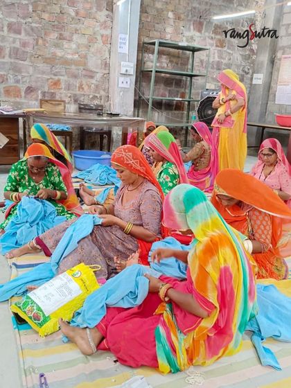 A group of women artisans in Bikaner, dressed in vibrant colors, work together on pieces for our Baori collection.