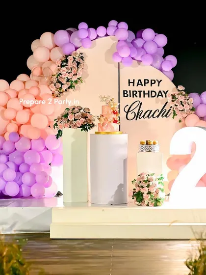 We specialize in large-scale, personalized decorations for milestone events like a 21st birthday. This outdoor setup features a custom-split arched backdrop, a pastel balloon garland, and large light-up marquee numbers to make the occasion feel extra special.