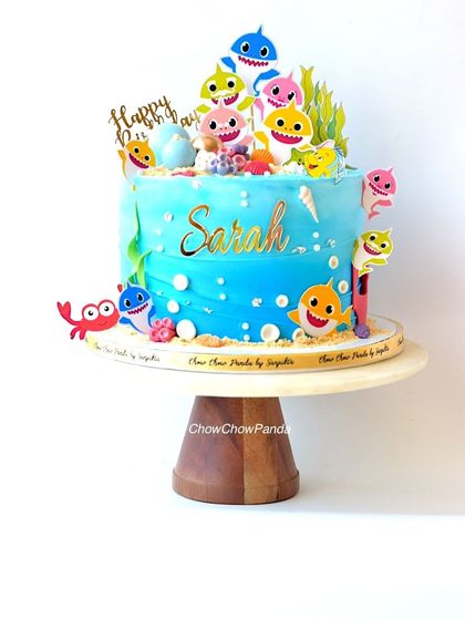 A fun and colourful Baby Shark cake, perfect for a toddler's birthday. This Black Forest cake is decorated with the whole shark family, edible bubbles, and seaweed details to create an underwater scene.