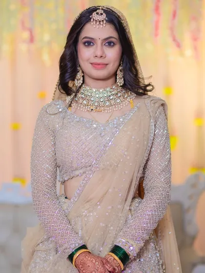 A portrait of the bride at her reception. The soft, neutral-toned makeup complements her shimmering lehenga perfectly.