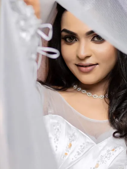 A model posing with a white veil, creating a soft and mysterious Christian wedding portrait.