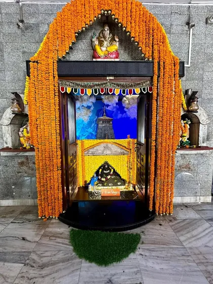 A wider view of our Kedarnath temple replication. The grand arch of marigolds frames the sacred shrine, with a Ganesha idol placed at the top to bless the entire space and all who enter.