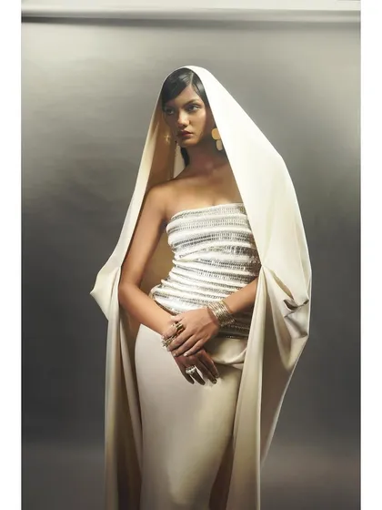 A three-quarter shot of the hooded gown, focusing on the sequined bodice and the model's poised expression. The styling emphasizes grace and sophistication.