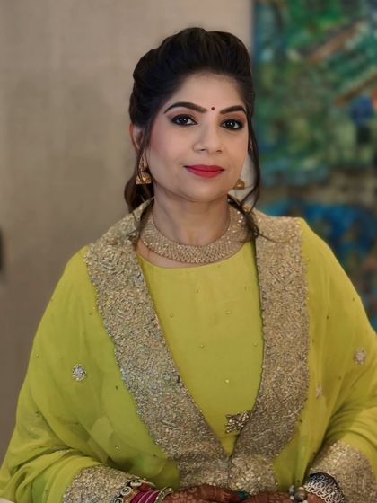 A full view of our client's festive look. The bright yellow outfit is perfectly complemented by the sophisticated ponytail and flawless makeup.