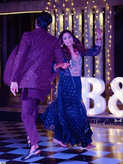 A candid moment of dance and laughter. The motion and happiness in this photo perfectly capture the spirit of a Sangeet night.