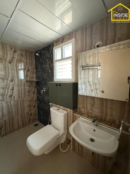 Even bathrooms deserve a touch of luxury. For this space, we used elegant, marble-patterned wall tiles and a compact vanity to create a clean, high-end feel.