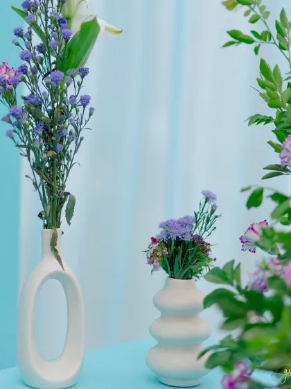 Minimalist and modern decor details. These contemporary white vases with simple purple floral stems add a touch of artistic flair to the overall design.