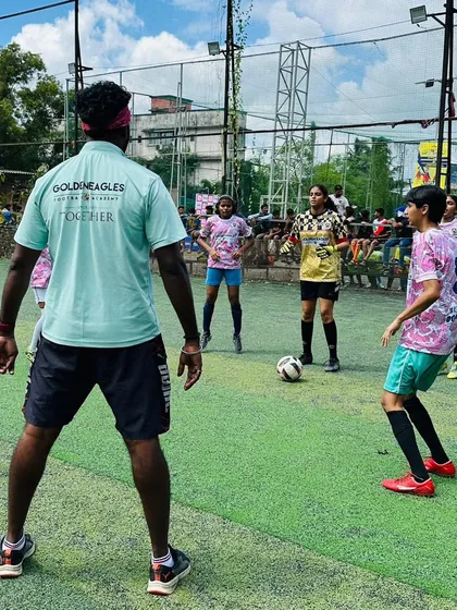 A coach observes a girls' training session, providing real-time feedback. We offer dedicated coaching to help our female players master their technique and game strategy.