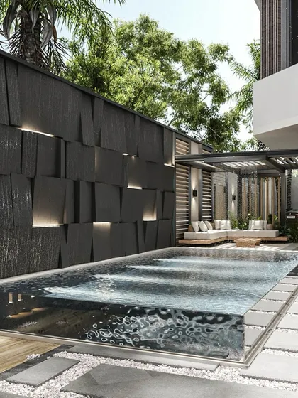A standout feature of this patio design is the custom glass-walled swimming pool. It creates a stunning visual effect, complemented by a textured feature wall with integrated lighting and a serene lounge area, blending architectural innovation with natural tranquility.