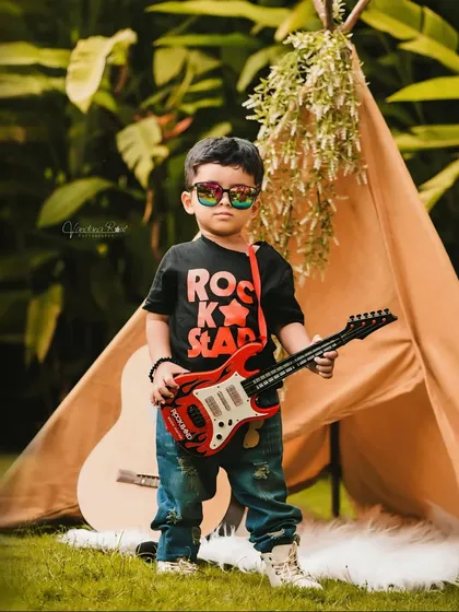 Let your toddler's personality shine with a fun, creative theme like this 'Rockstar' setup. Complete with a guitar, cool sunglasses, and a stage-like tent, it’s a perfect way to capture their playful energy during an outdoor kids photo session.