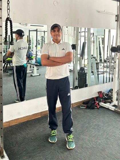 A full-body shot in the gym, showing a ready and athletic stance.