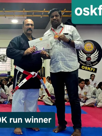 Presenting an award to the winner of the 10k run, a mandatory part of our black belt exam. This highlights our focus on holistic fitness, including cardiovascular endurance, as part of martial arts mastery.