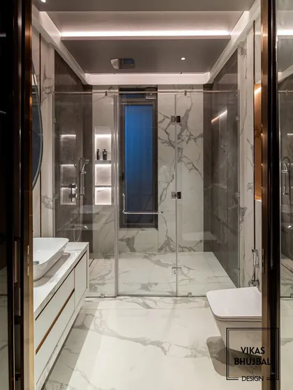 A frontal view of the same bathroom, showcasing the clean lines of the floating vanity and the seamless glass shower door. The design feels spacious, modern, and impeccably detailed.