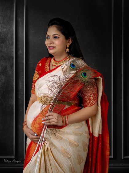 A touch of divinity. The peacock feather, associated with Lord Krishna, adds a beautiful and symbolic element to this traditional maternity portrait.
