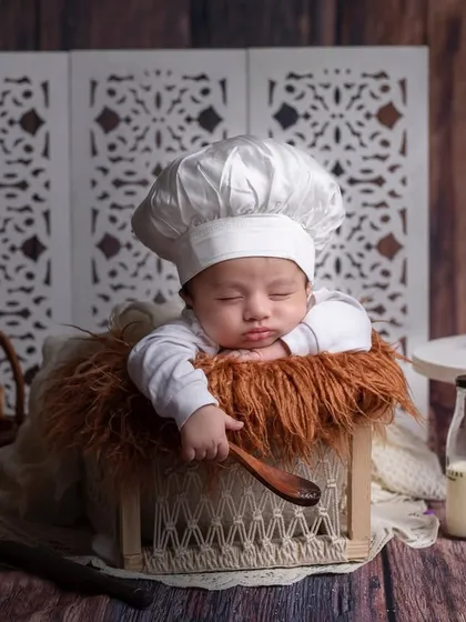 Baked with love. A newborn baker sleeps peacefully in a basket, surrounded by all the ingredients for a sweet life.