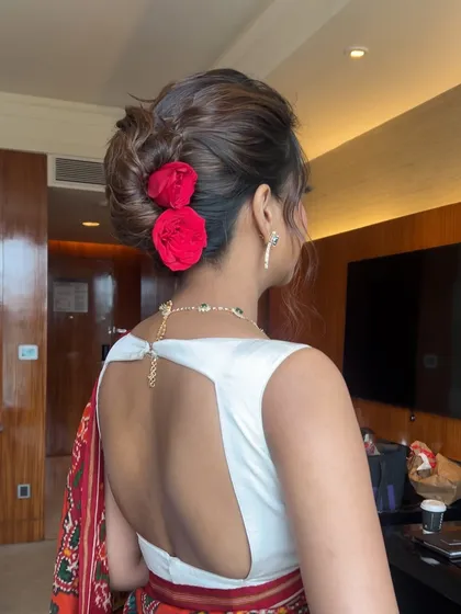 A back view of the rose bun, showing how it perfectly complements the client's open-back blouse.