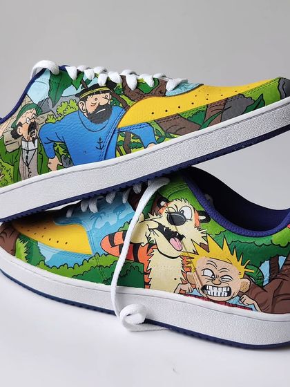 A stacked view of the Tintin and Calvin and Hobbes custom sneakers. I removed the Nike swoosh on this pair to have a larger, cleaner canvas to work with.