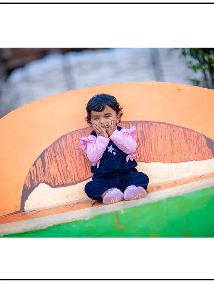 A shy but sweet "peek-a-boo" moment. I love capturing these little gestures that showcase your child's budding personality.