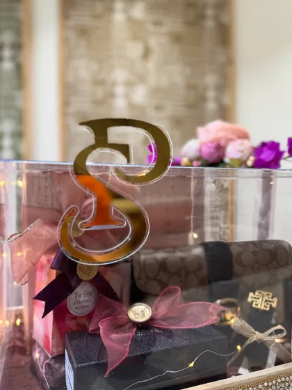 The bride's initial in a golden acrylic cutout adds a bold and personal statement to her trousseau box.