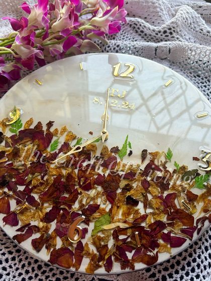 This custom wall clock is made with preserved red and yellow petals from a varmala. The design is clean and modern, with simple hour markers and the wedding date subtly included.
