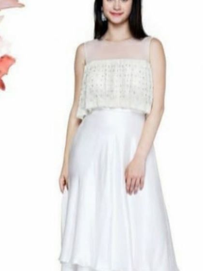 A stylish white layered gown with a pearl-embroidered overlay on the bodice. The combination of net and georgette gives it a light, airy feel, making it a great option for a summer evening event.