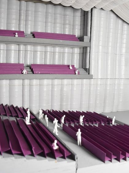 This detailed interior model of an auditorium tests seating arrangements, sightlines, and acoustics. The use of color and scale figures helps us simulate the human experience of the space, ensuring functionality and comfort.