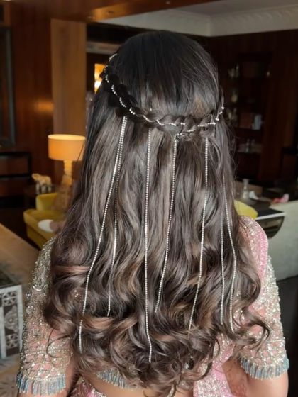 For a Mehendi look that is both modern and ethereal, I styled the hair in a half-up braided crown with soft waves. To add a touch of sparkle, I incorporated delicate, dangling stone strings that catch the light beautifully.
