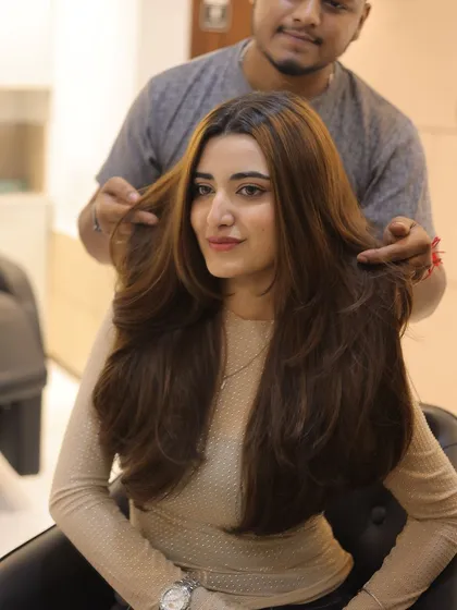 A happy client with her freshly styled hair. The layers and blowout work together to create a look that is both glamorous and effortless.