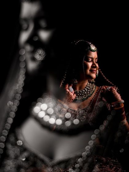 Here, I played with reflections and light to capture a moment of pure happiness. The bokeh effect from the jewelry adds a sparkling, magical quality to this candid bridal shot.