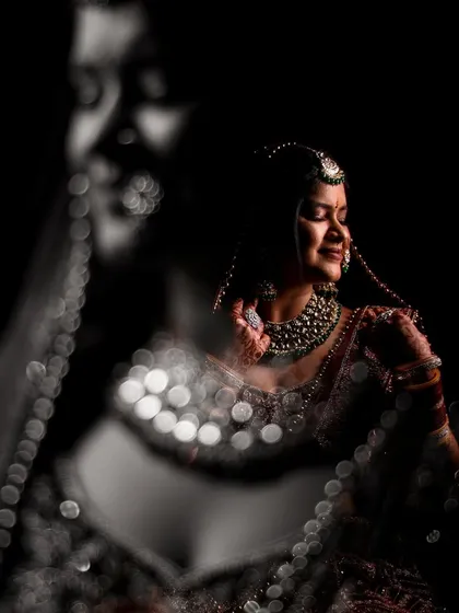 Here, I played with reflections and light to capture a moment of pure happiness. The bokeh effect from the jewelry adds a sparkling, magical quality to this candid bridal shot.