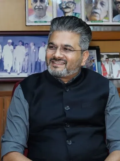 A candid moment in the chairman's office before the event, surrounded by portraits of great national leaders.