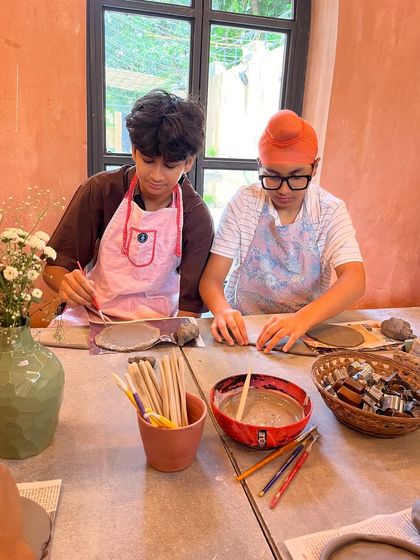 Our 'Clay & Play' playdates are a perfect afternoon activity. Here, two boys are focused on their hand-building projects, with all the tools and clay they need right at their fingertips.