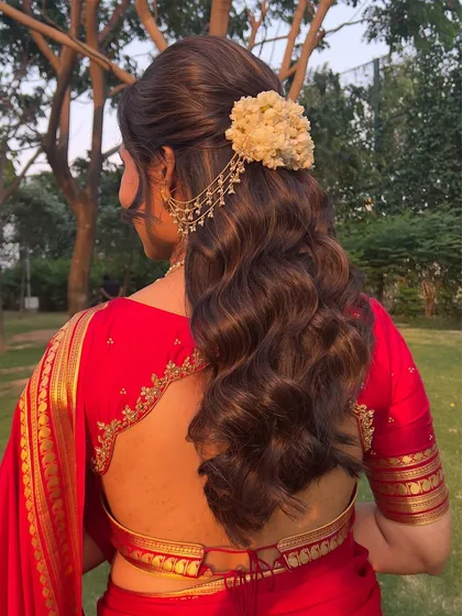 A back view of the half-updo, showing the lush curls and the beautiful jasmine and chain accessory.