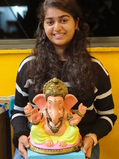 The smile of accomplishment says it all. This student is thrilled with her finished Ganpati idol, beautifully painted and ready for the Ganesh Chaturthi celebrations.