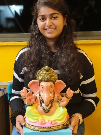 A participant with her beautifully decorated Ganpati idol. The workshop allows everyone to add their personal touch, making each idol unique.