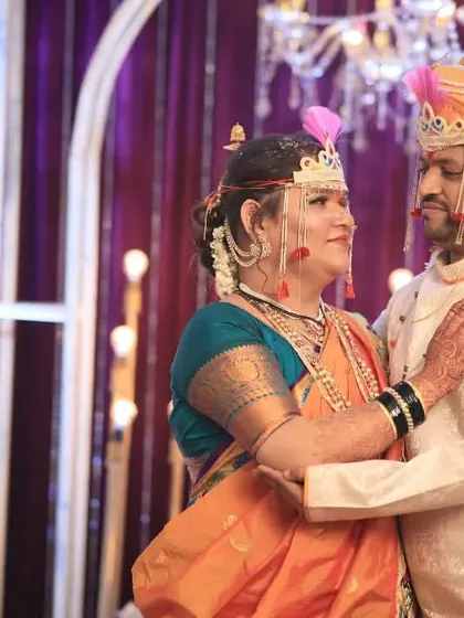 A tender moment between the newly married couple, framed by the elegant decor of their Maharashtrian wedding reception.