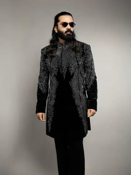 This black velvet indowestern is fully embellished with cascading silver beadwork. It's a glamorous and modern option for a cocktail party or New Year's Eve event.