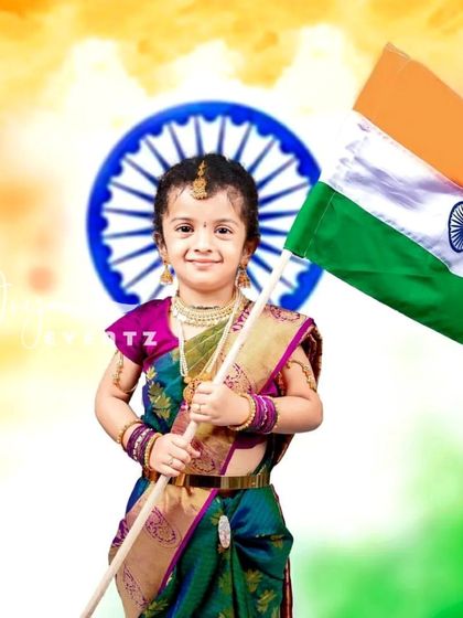 A patriotic Bharat Mata themed kids' photoshoot. Dressed in a traditional saree and holding the Indian flag, this little girl embodies the spirit of the nation in a proud and beautiful portrait.