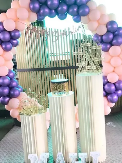 A purple and pink balloon ring with modern white pedestals.