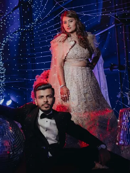 A stylish shot of the couple at their Sangeet, posing with disco balls for a fun, retro vibe.