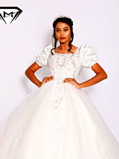 A classic princess silhouette with a modern twist. This white ball gown features elegant puffed sleeves and a delicately embroidered bodice, perfect for a timeless bridal look.