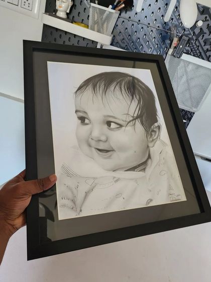 The baby portrait in a black frame.