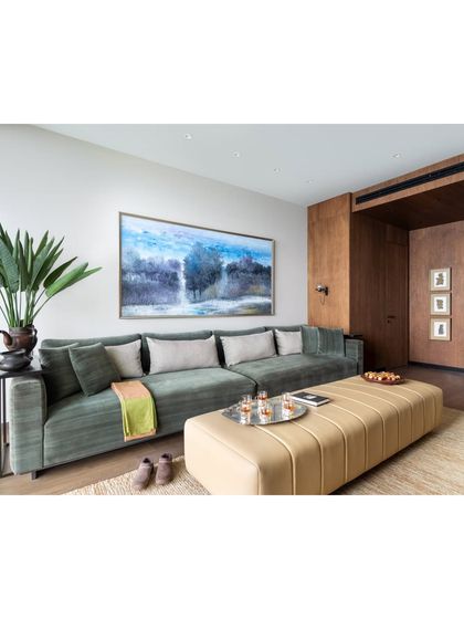 A wider view of the family lounge, showing the generous scale of the custom sofa and ottoman. The space is designed to be an understated, cozy heart of the home, where the family can gather and relax in a comfortable and stylish environment.