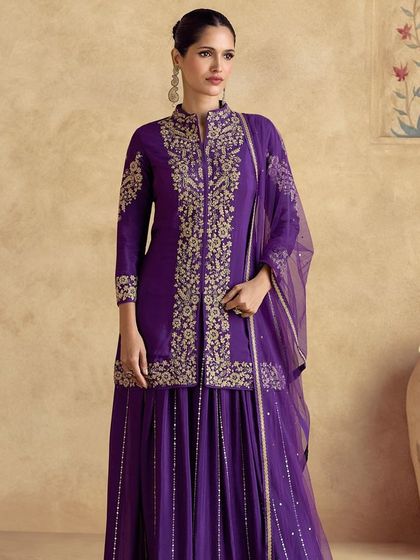 Feel like royalty in this violet premium silk palazzo suit. The intricate thread embroidery on the jacket-style top gives it a majestic look, perfect for a wedding or formal event.
